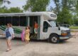 a family of three getting off the bus