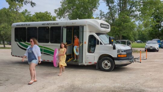 a family of three getting off the bus